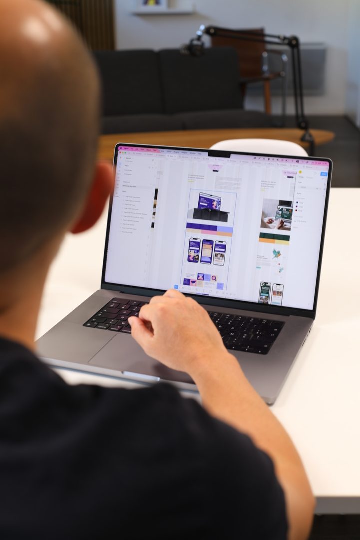 Designer travaillant sur une maquette de site web pour transformer une stratégie de communication en outil concret